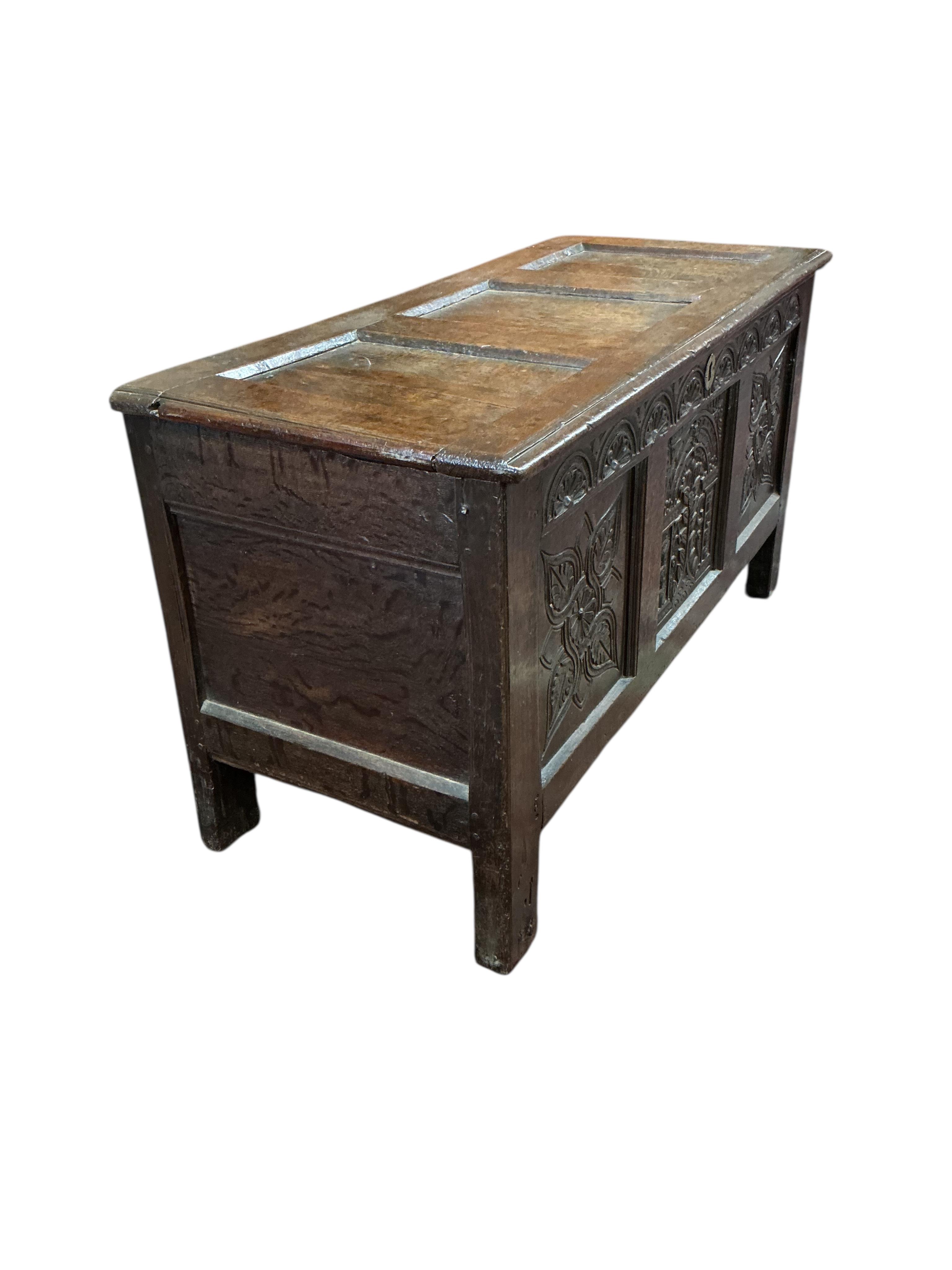 An 18th century carved oak coffer, width 124cm, depth 54cm, height 67cm